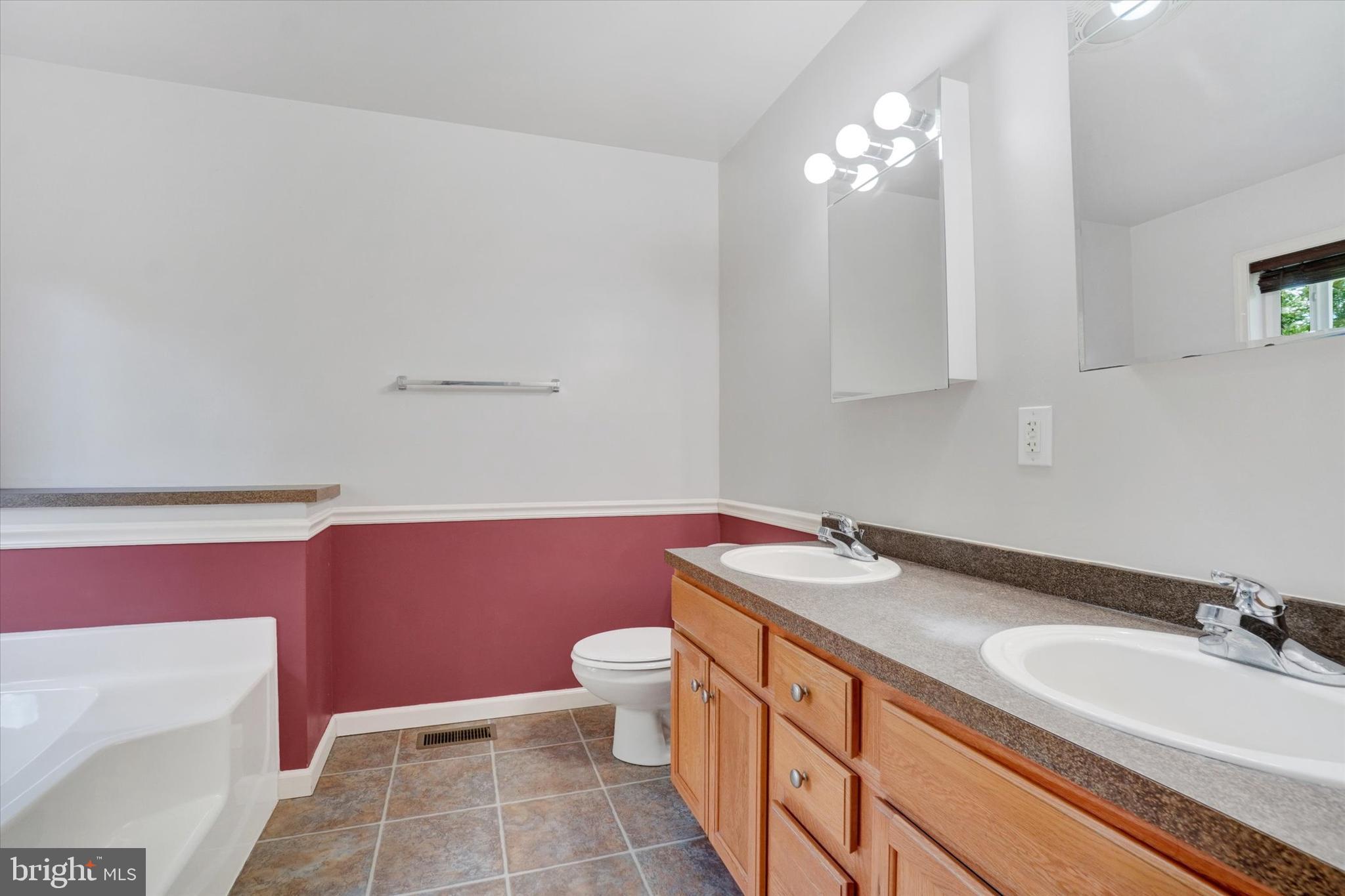 1055 Copenhaffer Road York, PA 17404 - Photo 25 of 38 a spacious bathroom with a granite countertop toilet a sink and a mirror