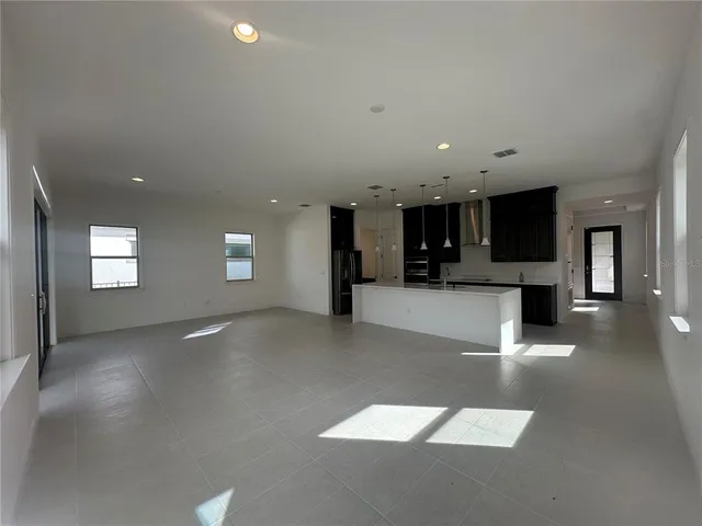 a view of a living room with kitchen view and a fireplace