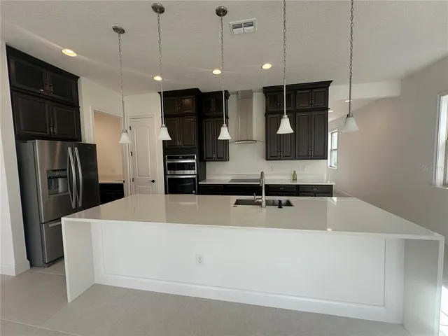 a large kitchen with stainless steel appliances kitchen island a large counter top