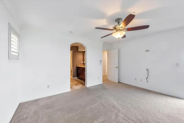 an empty room with closet and a ceiling fan