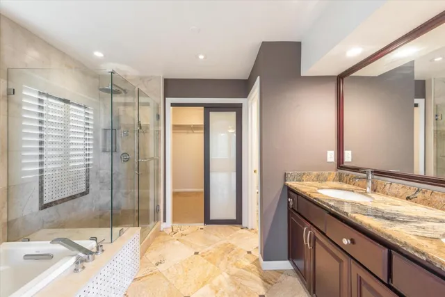 a bathroom with a granite countertop sink and a mirror
