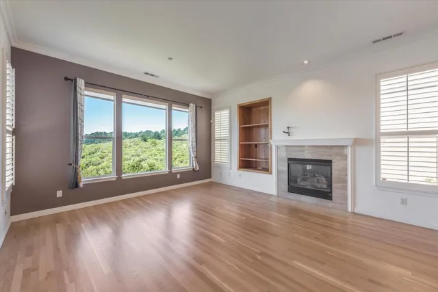wooden floor fireplace and windows in an empty room