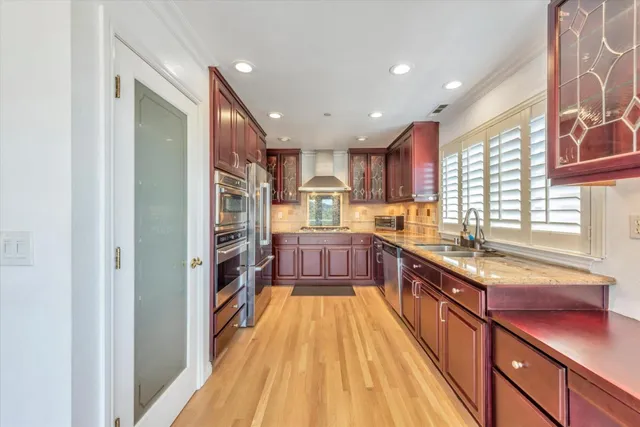 a large kitchen with stainless steel appliances granite countertop a large counter top a stove and a refrigerator