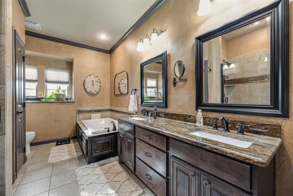 1132 Chartres Street Kaufman, TX 75142 - Photo 13 of 25 Bathroom featuring a jetted soaking tub, dual vanity with undermount sinks, and a walk-in shower with tile surround