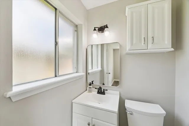a bathroom with a sink a toilet and a mirror