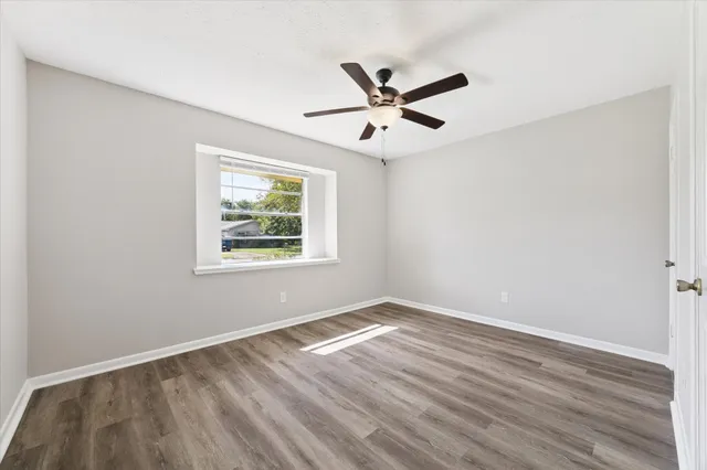 a view of a big room with wooden floor closet and windows