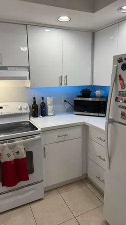 a kitchen with white cabinets and white appliances