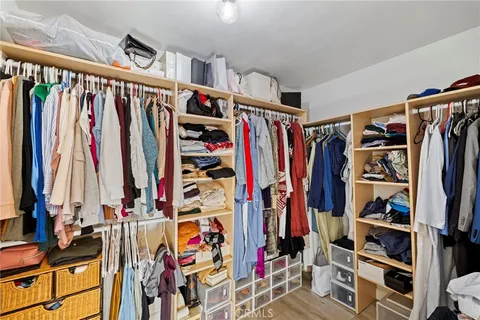 a view of walk in closet with clothes