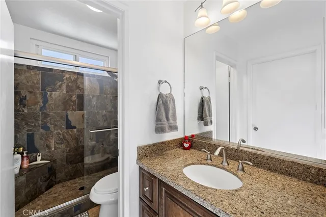 a bathroom with a granite countertop sink toilet and shower