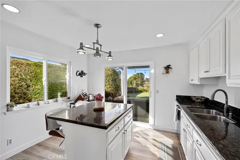 a kitchen with stainless steel appliances granite countertop a sink and a refrigerator