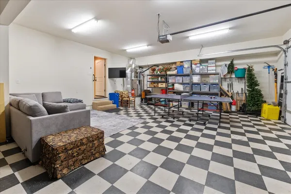 a living room with a black white checkered floor with couches chair and a coffee table