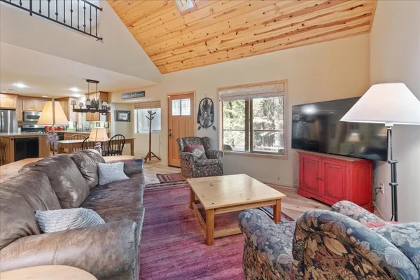 a living room with furniture a red lamp and kitchen view