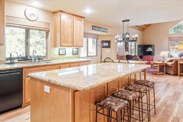 a dining hall with stainless steel appliances granite countertop a sink and a large window