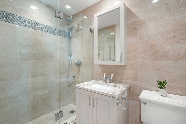a bathroom with a granite countertop sink and a potted plant