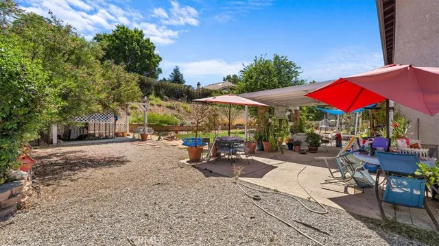 a view of the patio with a table and chairs under an umbrella