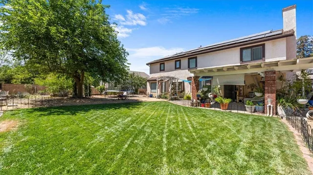 a front view of a house with garden and sitting area
