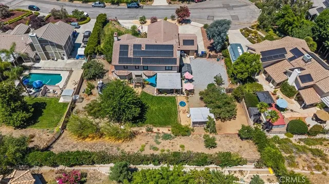an aerial view of residential houses with outdoor space and trees