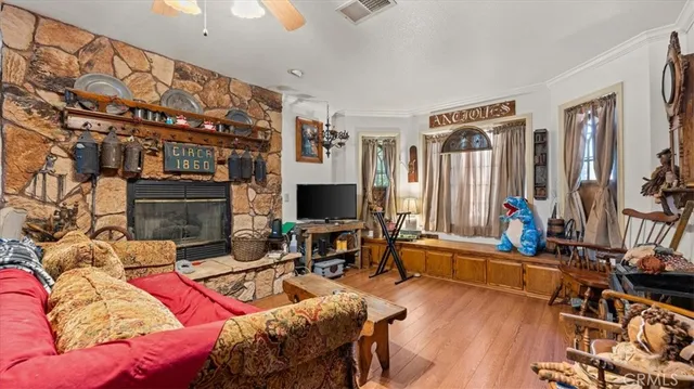 a living room with furniture a flat screen tv and wooden floor