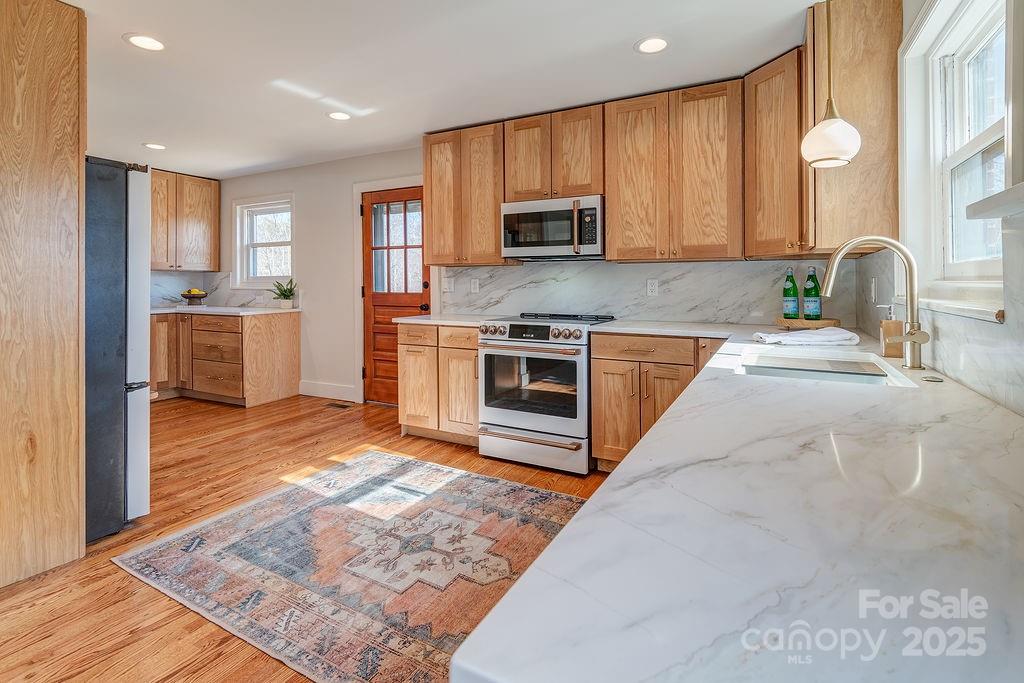 55 Cisco Road Asheville, NC 28805 - Photo 13 of 38 a large kitchen with stainless steel appliances granite countertop a stove a sink dishwasher and a microwave oven with white cabinets