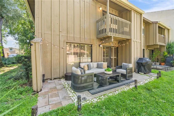 a view of a patio with couches table and chairs and potted plants