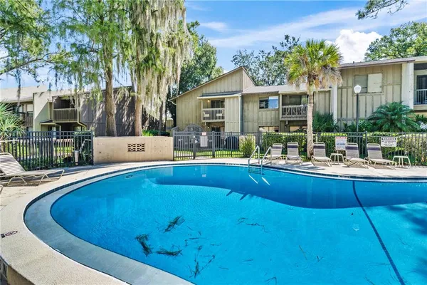 a view of swimming pool with outdoor seating and plants