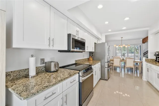 a kitchen with granite countertop a sink a stove and cabinets