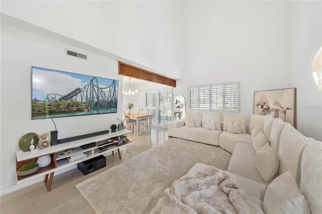 a living room with furniture a flat screen tv and a window