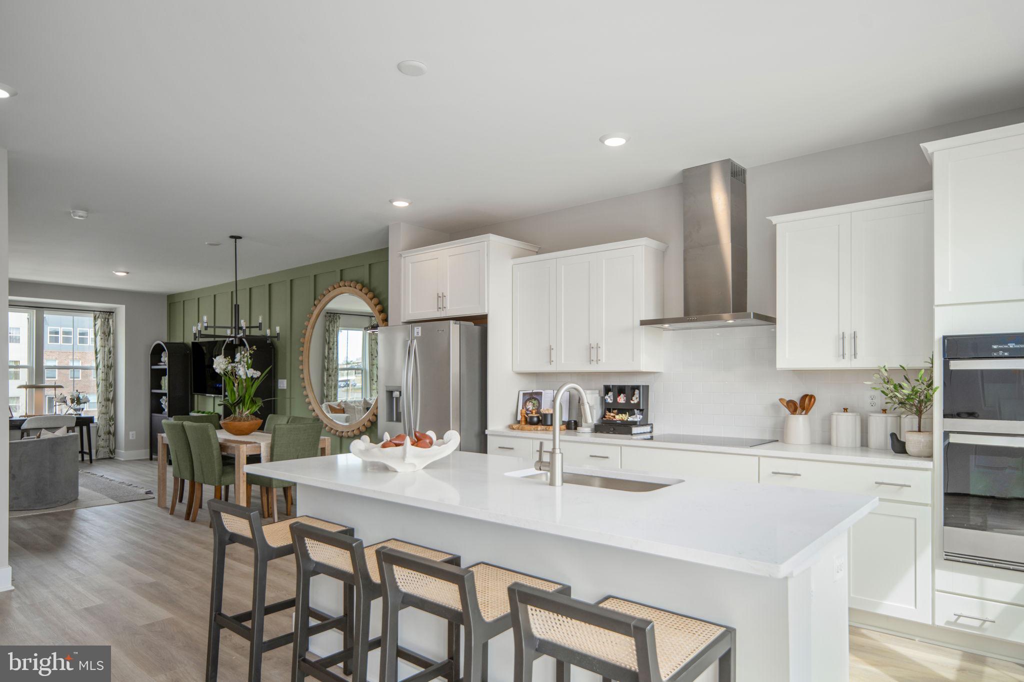 11367 Hypatia Loop Manassas, VA 20110 - Photo 22 of 80 a kitchen with stainless steel appliances a sink a stove a dining table and chairs