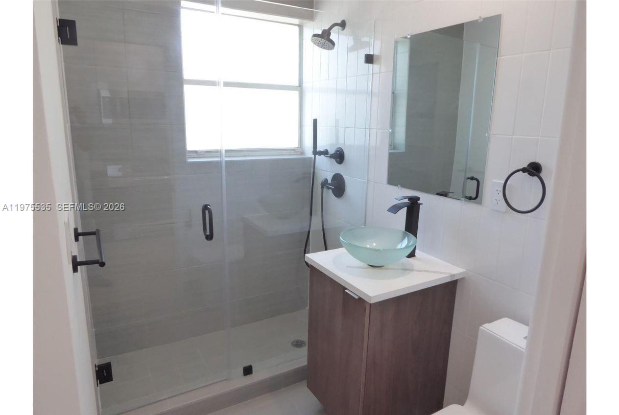 1000 7th Street Miami Beach, FL 33139 - Photo 19 of 36 a bathroom with a sink a mirror and a shower