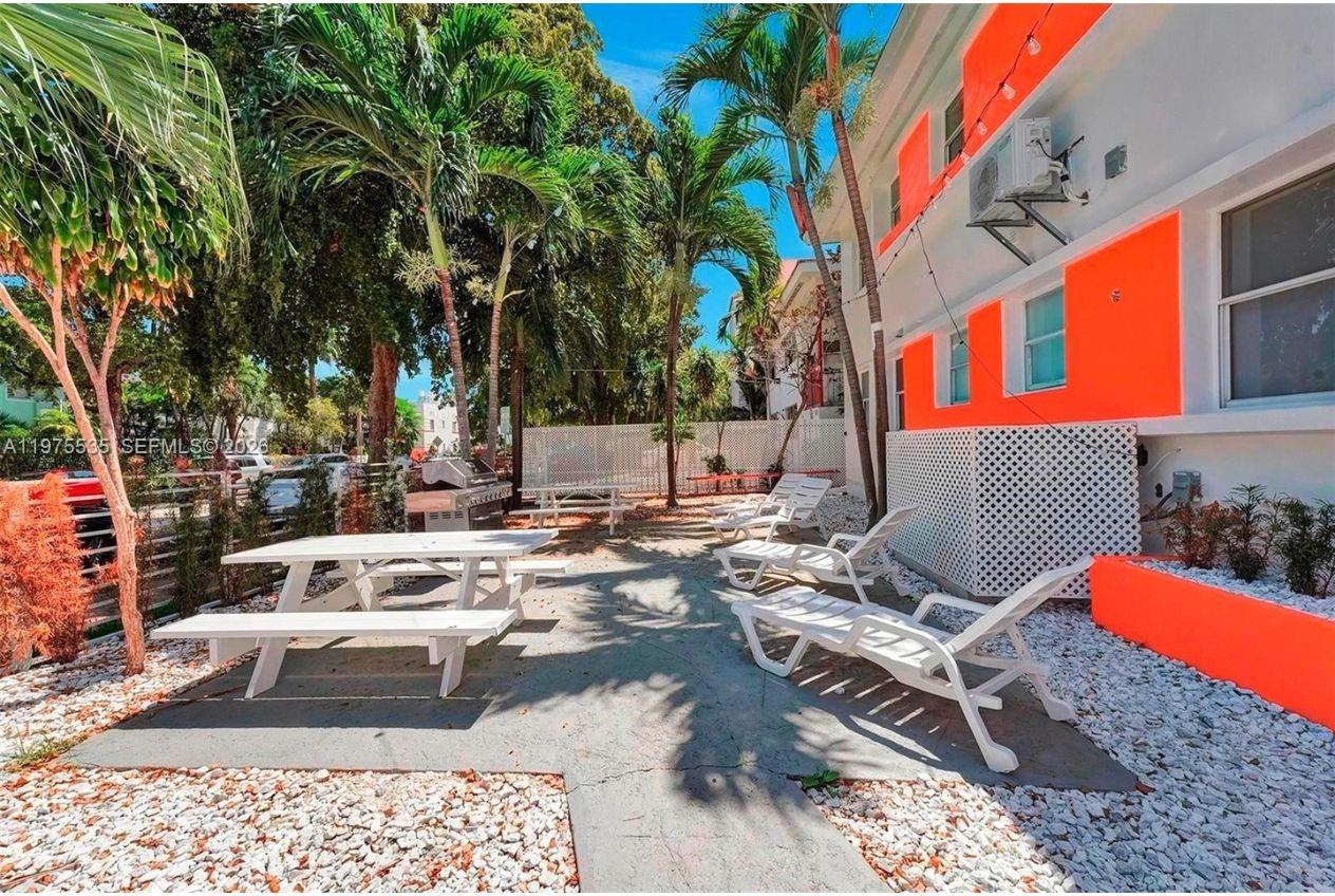 1000 7th Street Miami Beach, FL 33139 - Photo 23 of 36 a view of swimming pool with lounge chair and dinning table under an umbrella