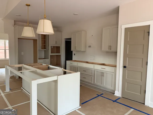 a kitchen that has a lot of cabinets in it and stainless steel appliances