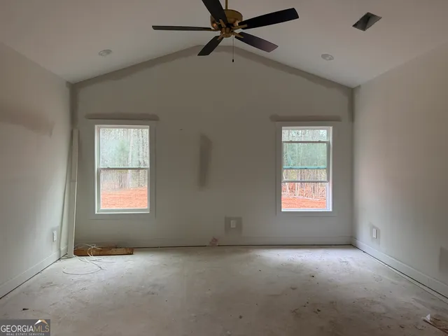 an empty room with a window and a fan
