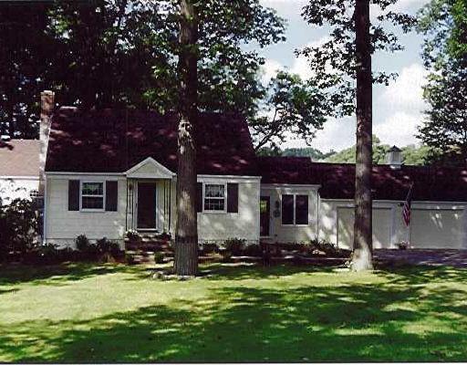 a front view of house with yard seating and green space