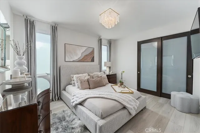 a bedroom with a large bed and a chandelier