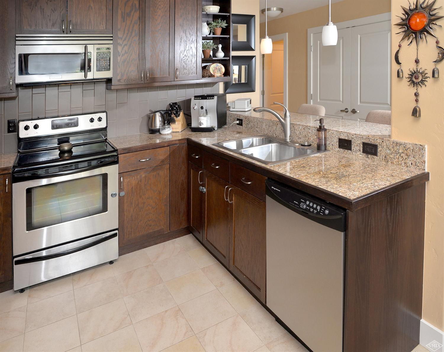 80 Freestone Road, Unit B201 Eagle, CO 81631 - Photo 7 of 15 a kitchen with stainless steel appliances granite countertop a sink stove and microwave