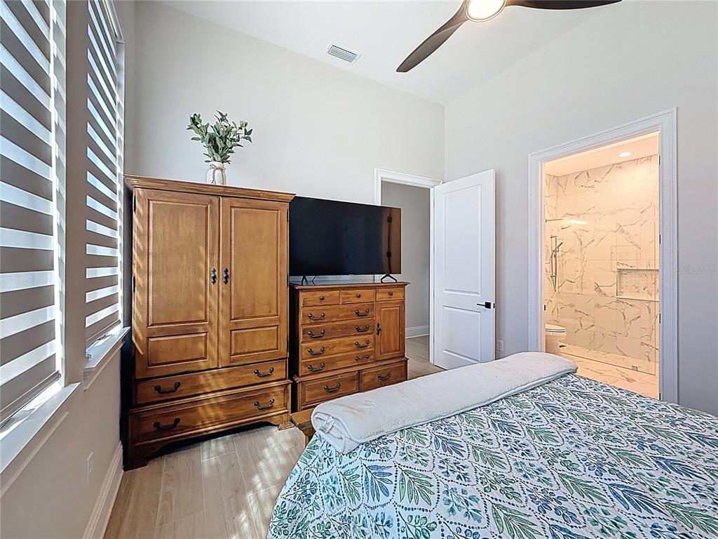 7394 Gathering Court Reunion, FL 34747 - Photo 19 of 44 a bedroom with a bed and a flat screen tv