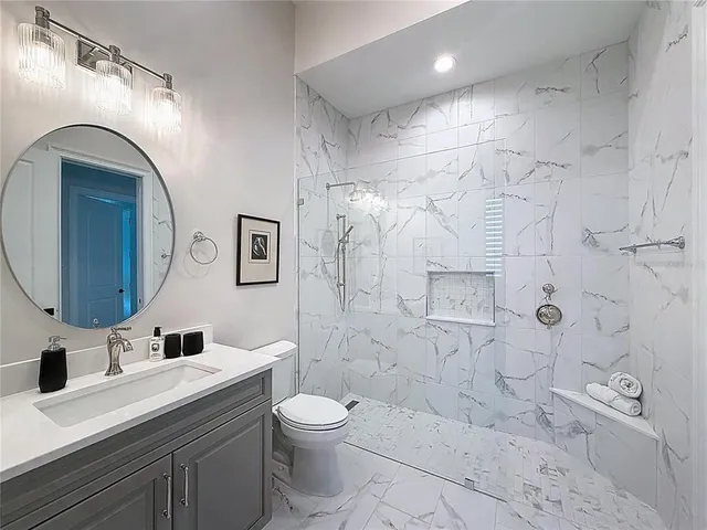 a bathroom with a sink a toilet and shower