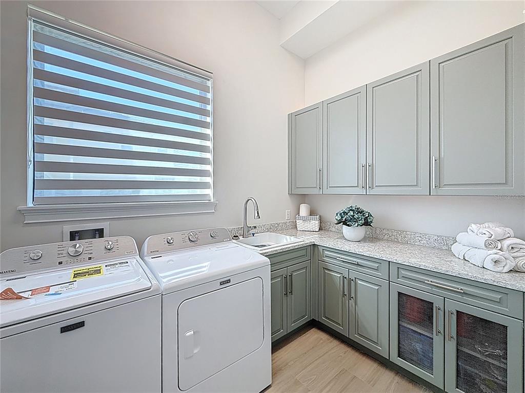 7394 Gathering Court Reunion, FL 34747 - Photo 23 of 44 a utility room with cabinets washer and dryer
