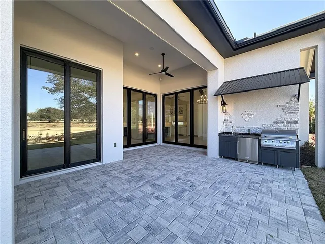 a large room with stainless steel appliances kitchen island granite countertop a refrigerator and a sink