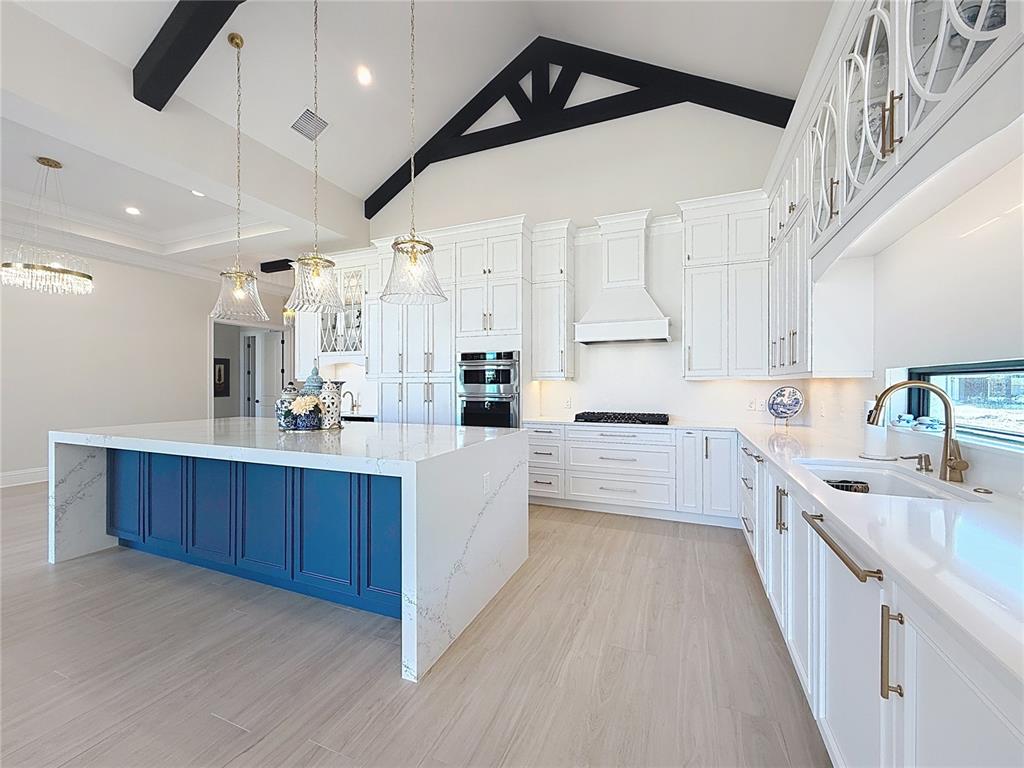 7394 Gathering Court Reunion, FL 34747 - Photo 8 of 44 a large white kitchen with kitchen island a large counter space a sink stainless steel appliances and cabinets