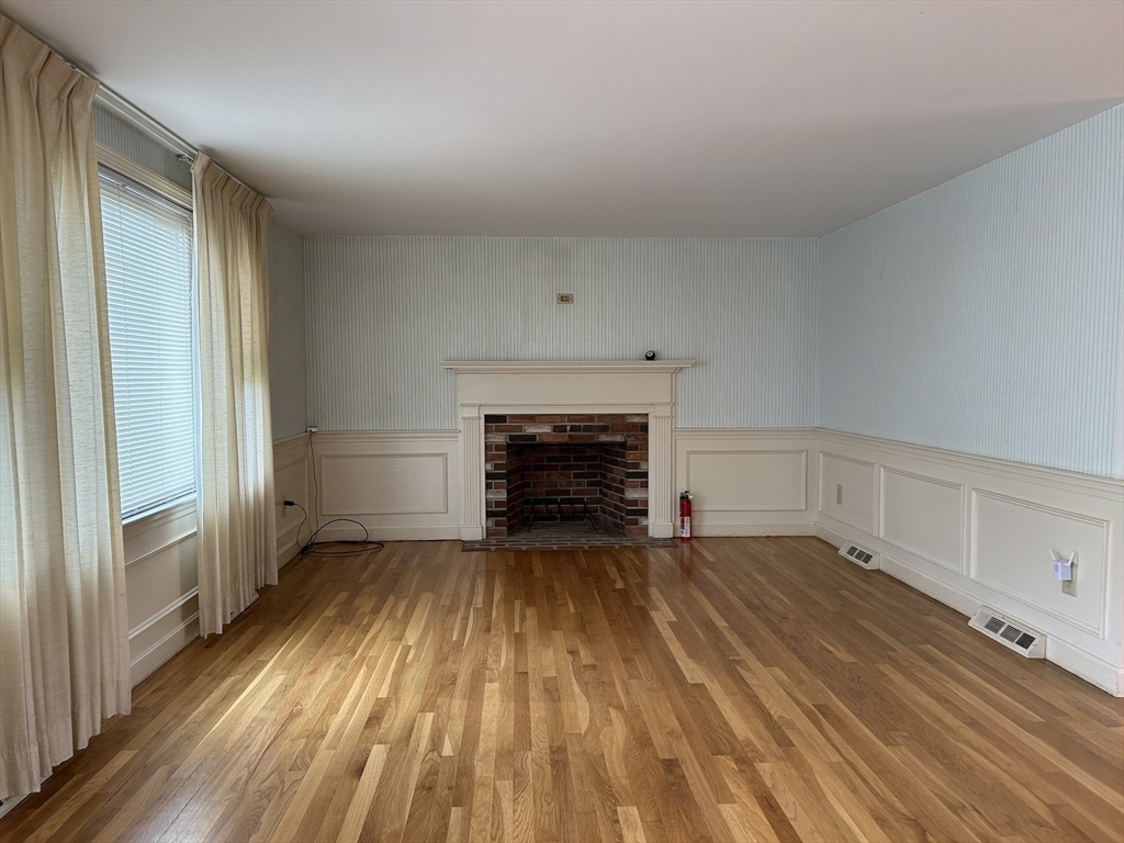 32 Westminster Road Centerville, MA 02632 - Photo 6 of 23 a view of an empty room with wooden floor fireplace and a window
