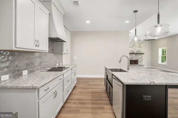 a kitchen with granite countertop a sink stove and cabinets