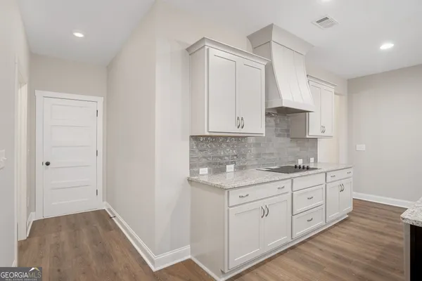 a kitchen with white cabinets and sink
