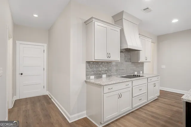 a kitchen with white cabinets and sink