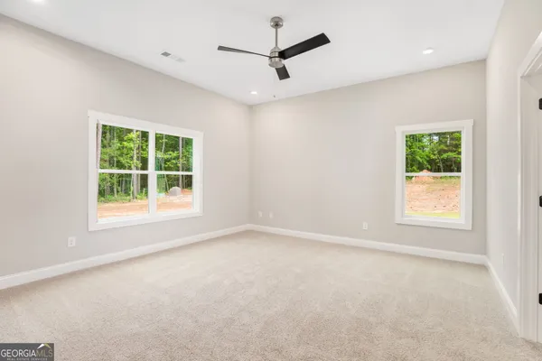 an empty room with a window and a ceiling fan