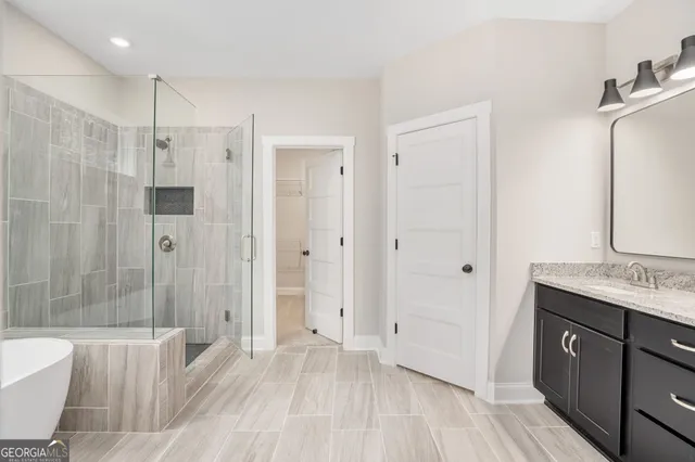 a spacious bathroom with a granite countertop sink a toilet a mirror and shower