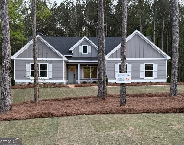 a view of a yard in front of a house with large trees