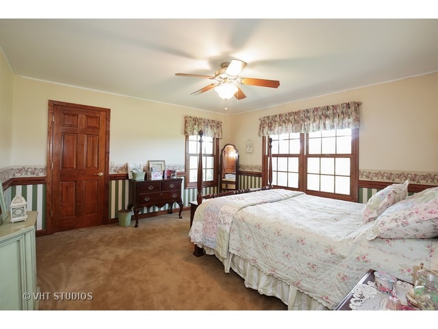 9N100 Percy Road Maple Park, IL 60151 - Photo 7 of 10 a bedroom with a large bed and a chandelier