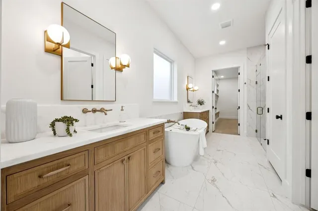 a spacious bathroom with a double vanity sink mirror and bathtub