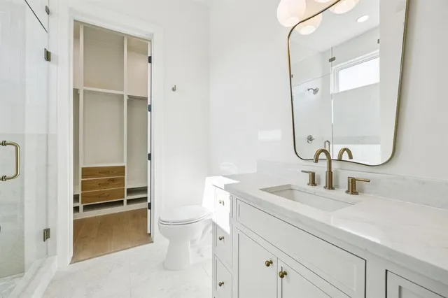 a bathroom with a sink a toilet and a mirror